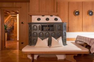 a stove sitting in the middle of a room with pillows at Dolomites Apartment Christian in Ortisei