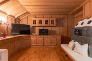 a living room with a television and a couch at Dolomites Apartment Christian in Ortisei