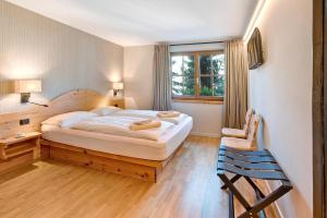 a bedroom with a large bed and a chair at Chalet Sonne - Livigno in Livigno