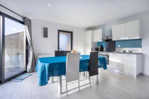 a kitchen and dining room with a blue table and chairs at Ty Kervignon 1 - 2,5kms de la plage in Plobannalec-Lesconil