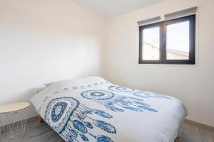 a bed in a white room with a window at Ty Kervignon 1 - 2,5kms de la plage in Plobannalec-Lesconil