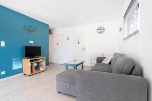 a living room with a couch and a tv at Ty Kervignon 1 - 2,5kms de la plage in Plobannalec-Lesconil