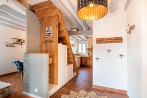 a room with a kitchen and a hallway with a refrigerator at La ferme du château in Venon