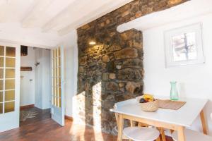 a kitchen with a table and a stone wall at La ferme du château in Venon +7 photos