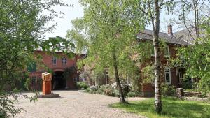 a red brick building with a statue in front of it at Künstlerwohnung im Naturpark in Meezen