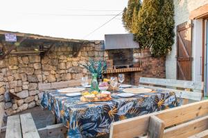 a table with a blue and yellow table cloth on it at La ferme du château in Venon
