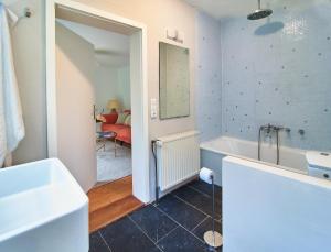 a bathroom with a tub and a sink and a mirror at Künstlerwohnung im Naturpark in Meezen