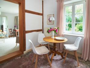 a dining room with a table and white chairs at Künstlerwohnung im Naturpark in Meezen