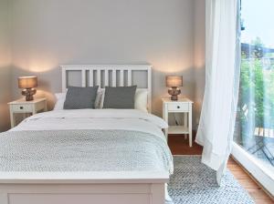 a bedroom with a white bed and a large window at Künstlerwohnung im Naturpark in Meezen