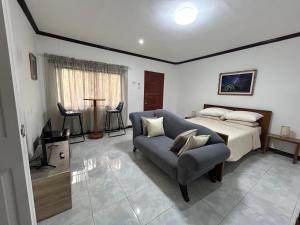 a bedroom with a bed and a couch at Seaside Villa in Dauis +41 photos