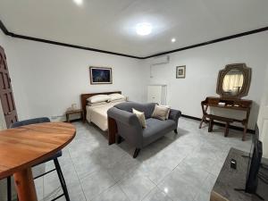 a bedroom with a bed and a couch and a table at Seaside Villa in Dauis