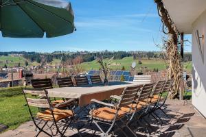 a table with chairs and an umbrella on a patio at Freiraum in Weiler-Simmerberg