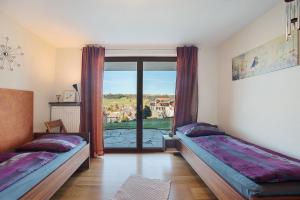 a bedroom with two beds and a large window at Freiraum in Weiler-Simmerberg