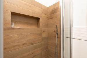 a bathroom with a shower with wooden walls at Civico17 in Santa Ninfa +16 photos