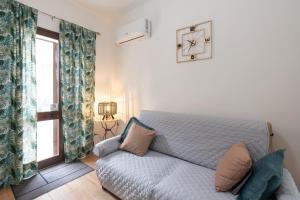 a living room with a couch and a clock on the wall at Civico17 in Santa Ninfa