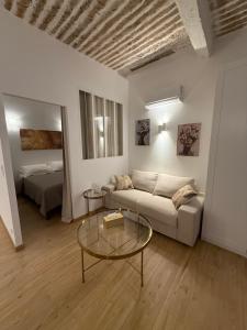 a living room with a couch and a table and a bed at Très Grand studio neuf 50 m du port Lovely charrons 2 in Saint-Tropez