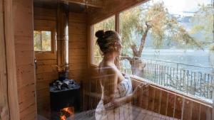 Eine Frau sitzt auf einem Balkon und schaut aus dem Fenster. in der Unterkunft lofthotel Walensee in Murg