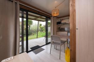 a kitchen and dining room with a table and sliding glass doors at Chalet 20m2 - Ile Vierge in Plouhinec