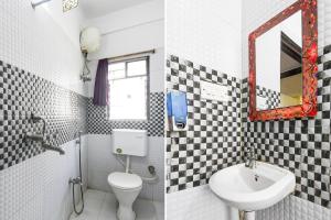 a bathroom with a sink and a toilet and a mirror at Hotel O New Alipore in Kolkata