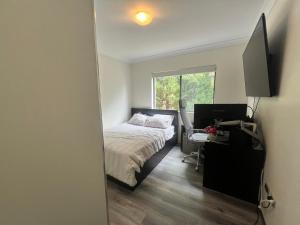 a bedroom with a bed and a desk and a window at The Castle in Castle Hill