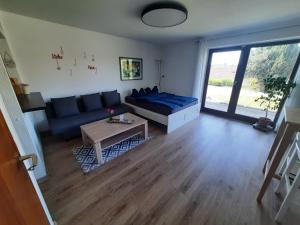 a living room with a blue couch and a table at Am Dorfweiher in Tettnang