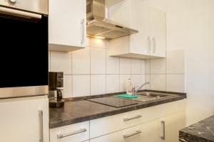 a kitchen with white cabinets and a sink at Am Dorfweiher in Tettnang