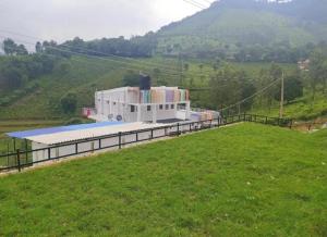 a building on a hill with a grass field at Green Valley in Kolakambe