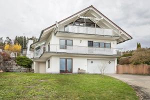 a large white house with a large balcony at Am Dorfweiher in Tettnang