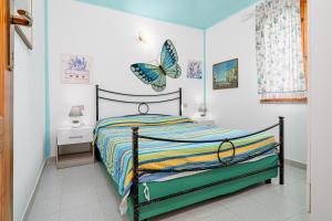 a bedroom with a bed with a butterfly on the wall at Quadrilocale Le Colonne in Lu Lioni