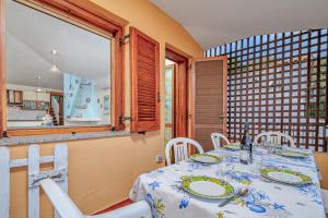 a dining room with a table and white chairs at Quadrilocale Le Colonne in Lu Lioni +16 photos