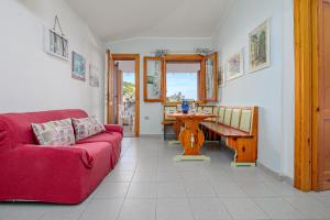 a living room with a red couch and a table at Quadrilocale Le Colonne in Lu Lioni