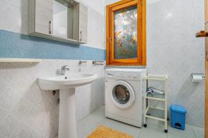 a bathroom with a washing machine and a sink at Quadrilocale Le Colonne in Lu Lioni