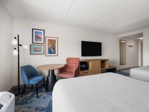 a hotel room with a bed and a desk and a tv at Hampton Inn Warrenton, Va in Warrenton