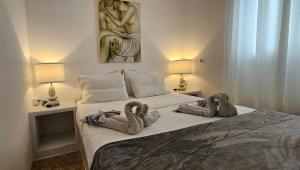 a bedroom with a bed with towel animals on it at Santorini Studios Pleasure in Perissa