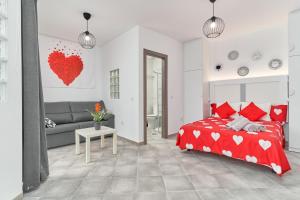 a bedroom with a red bed and a couch at Nerja Boutique B3 Sweet Corner in Nerja