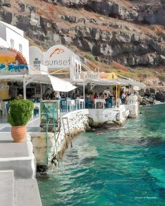 a restaurant on the side of a body of water at Santorini Studios Pleasure in Perissa