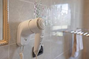 a hair dryer on the wall of a bathroom at Locanda Casa Bardacchino in Mango