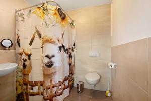 a bathroom with a shower curtain with animals on it at Ferienwohnung auf dem Ennerthof in Arnsberg