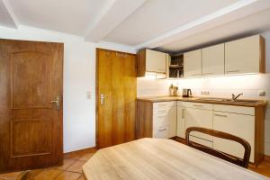 a kitchen with a table and a wooden door at Ferienwohnung auf dem Ennerthof in Arnsberg +13 photos