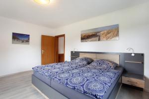 a bedroom with a bed with a blue comforter at Ferienwohnung auf dem Ennerthof in Arnsberg