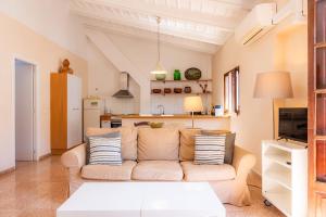 a living room with a couch and a kitchen at Can Claret in Felanitx