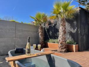 a table with a bottle of wine and two palm trees at La Saint Pabu'lle in Pléneuf-Val-André