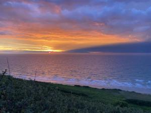a sunset over the ocean with a rainbow in the sky at La Saint Pabu'lle in Pléneuf-Val-André