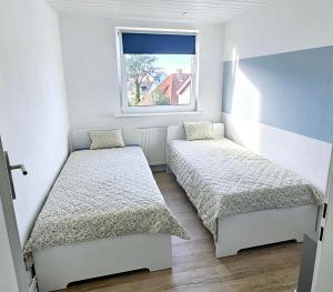 a small bedroom with two beds and a window at Büsummchen in Büsum