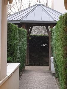 a pavilion with a walkway in a garden at Studio proche rer e in Rosny-sous-Bois
