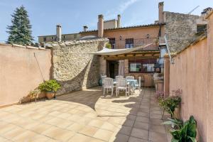 a patio with a table and chairs in front of a building at Grans Paisatges in Orriols