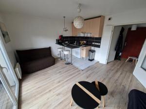 a small living room with a couch and a kitchen at Studio proche rer e in Rosny-sous-Bois
