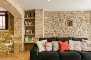 a living room with a black couch with colorful pillows at Grans Paisatges in Orriols