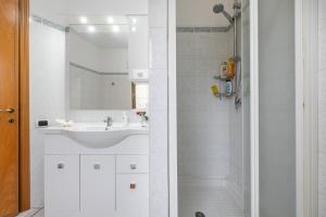 a white bathroom with a sink and a shower at Casa Colonia 1 in SantʼAnna Arresi +20 photos