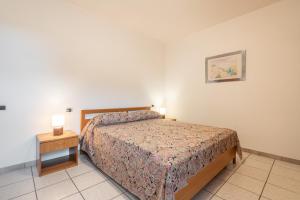 a bedroom with a bed and a nightstand and a bed sidx sidx sidx sidx at Casa Colonia 1 in SantʼAnna Arresi